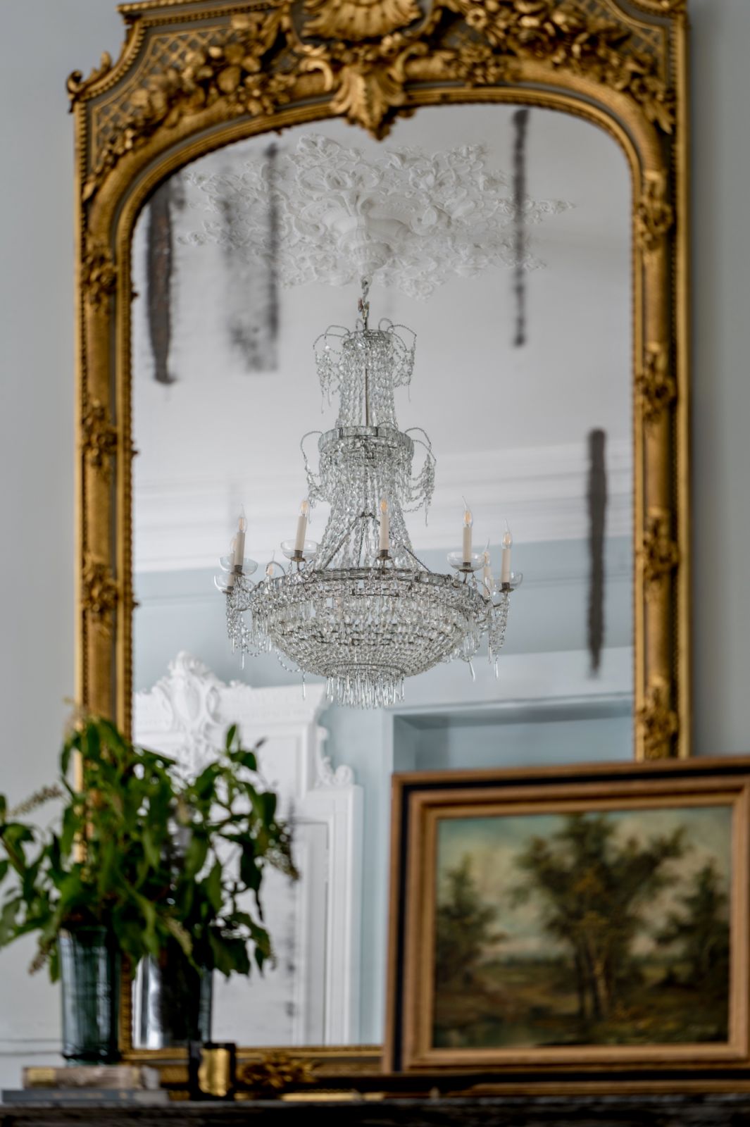 The antique chandelier’s delicate design plays off the glamorous architectural features