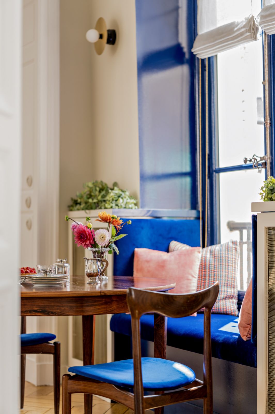 Henry Walter Klein’s midcentury teak chairs with reupholstered in bright blue fabric by Pierre Frey