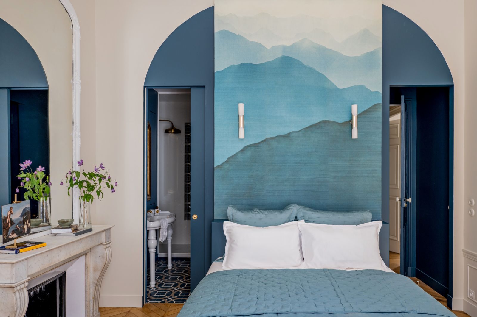Refreshing hues of blue in the guest room with arched doorways