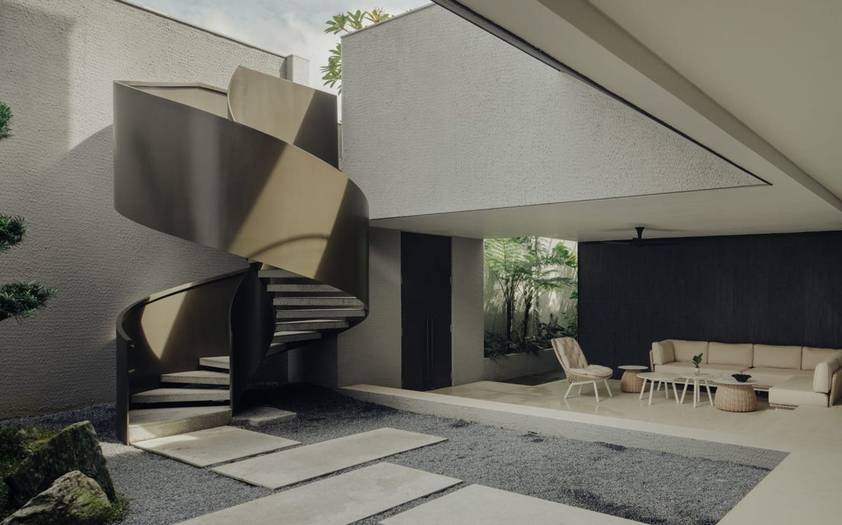 A view of the Good Class Bungalow's basement outdoor living area and its statement spiral staircase from the courtyard garden