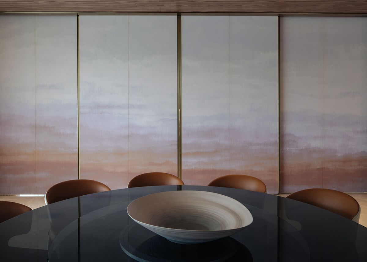 The Good Class Bungalow's informal dining room features folding door with artwork in sunset hues