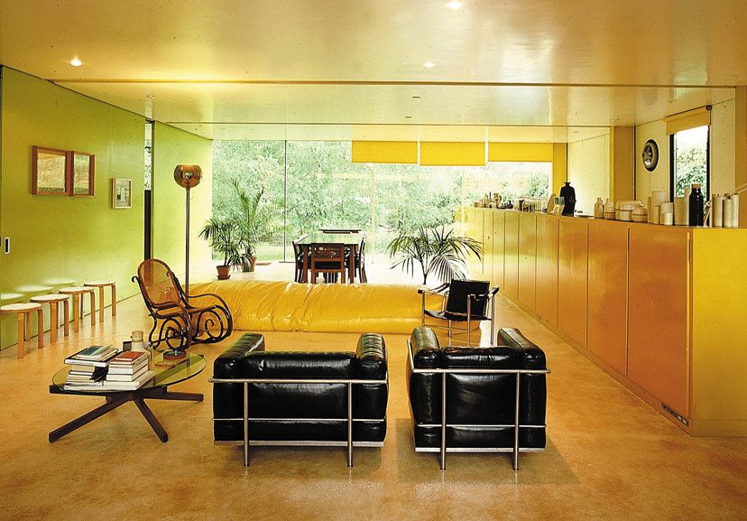 The interior of Richard Rogers’ 22 Parkside House in Wimbledon, London, features iconic yellow cabinetry, minimalist modern furniture, and floor-to-ceiling glass overlooking the garden (Photo: Courtesy of Rogers Stirk Harbour + Partners LLP_