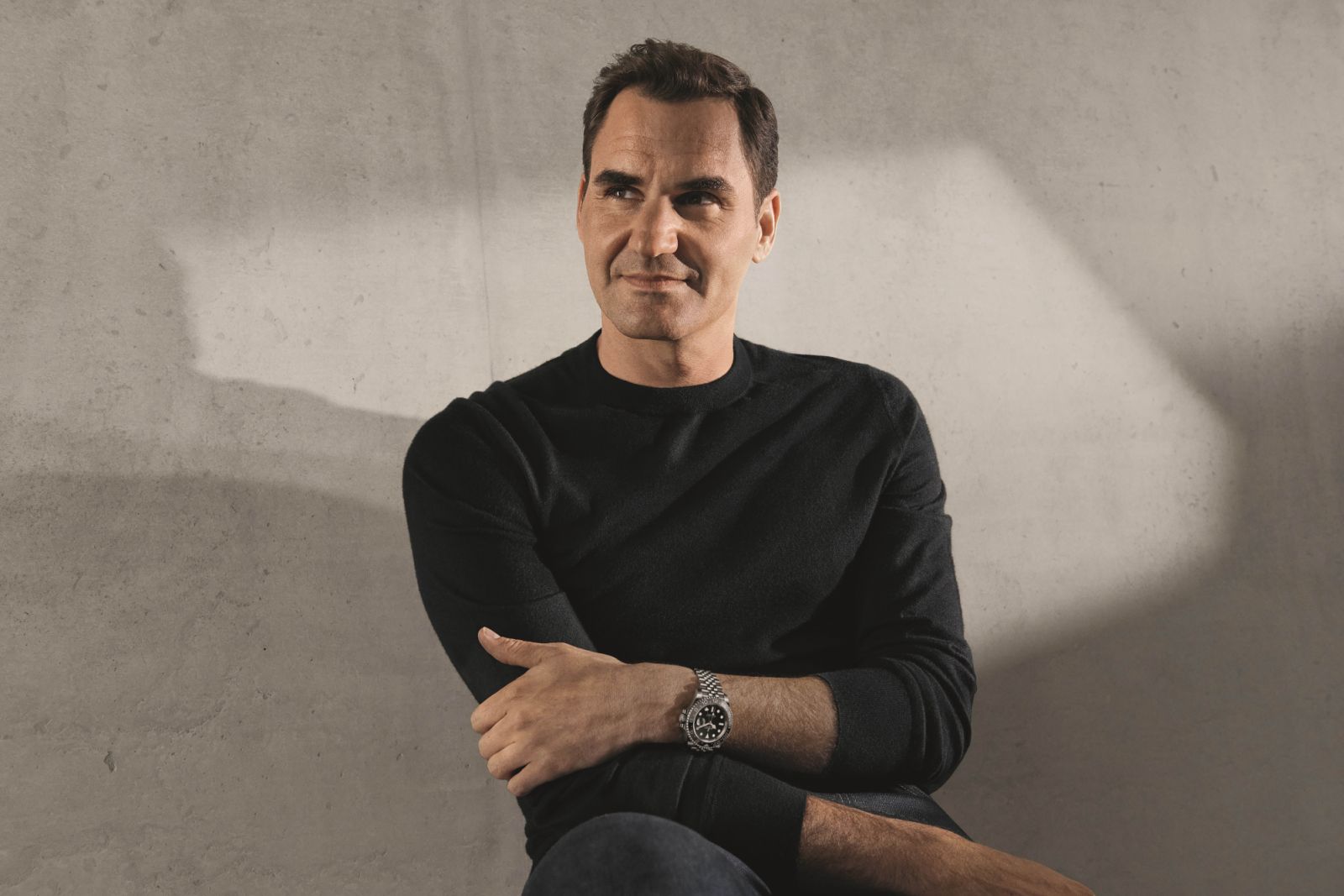 Roger Federer, former tennis player and Rolex Testimonee, with a GMT-Master II in Oystersteel on his wrist, featuring a bezel with a grey and black Cerachrom insert.