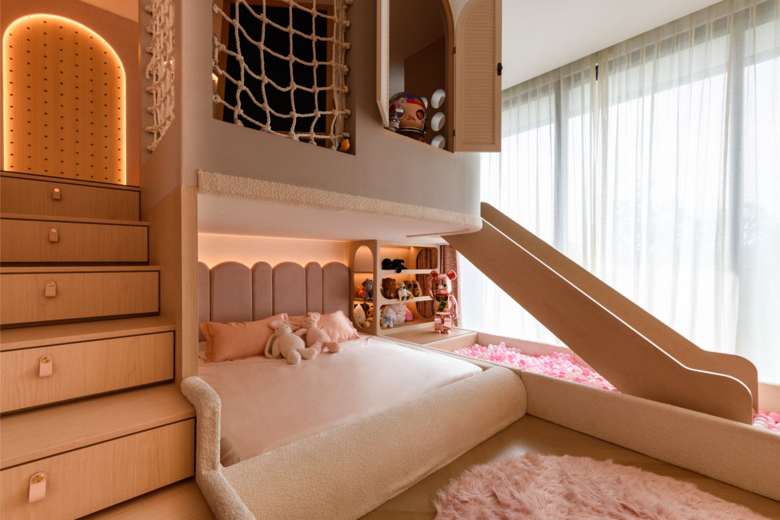 Custom double-story children's bedroom with rose gold slide and ball pool in this Damansara Heights penthouse designed for family living