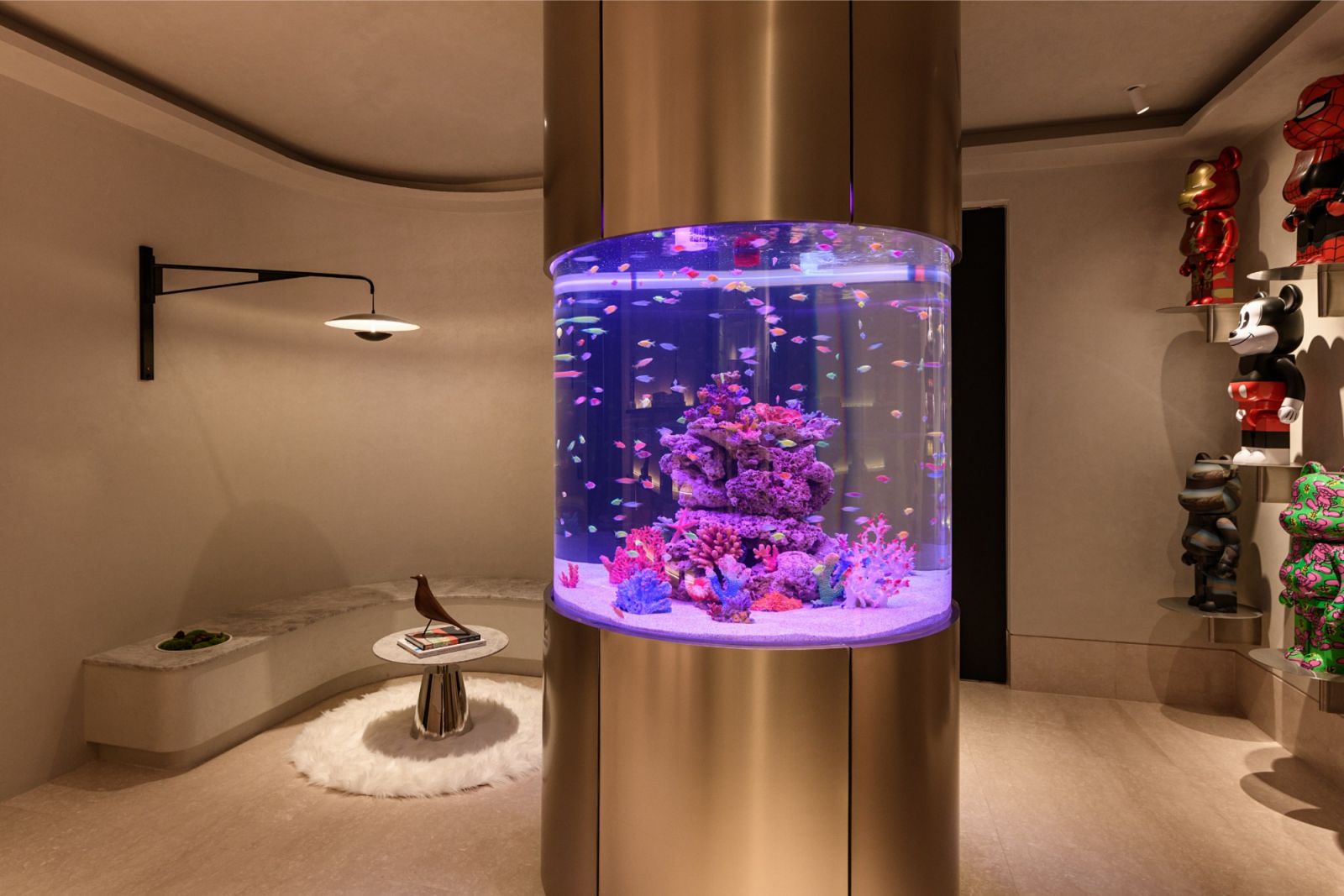 Statement cylindrical aquarium with vibrant coral and tropical fish, a central sculptural element in this penthouse interior