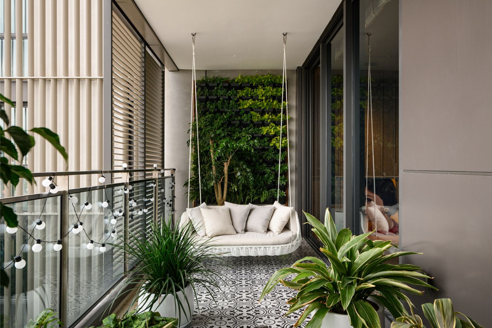 Santorini-inspired balcony with vertical green wall and suspended seating in this luxury Kuala Lumpur penthouse