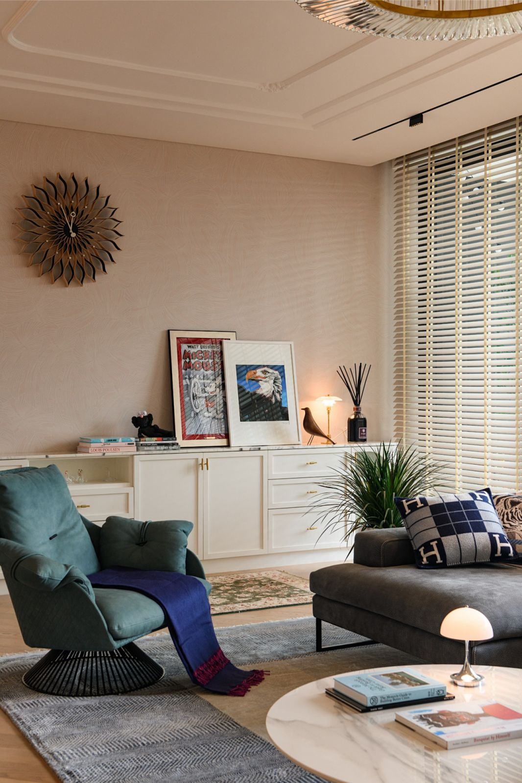 The living area is detailed with curated designer pieces, an Eames bird sculpture, and Hermès cushions in this penthouse renovation