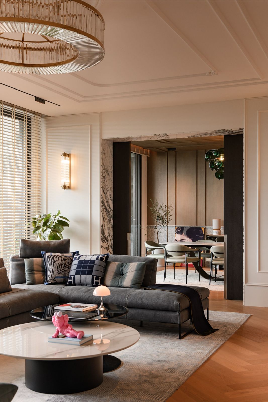 Living room with crystal chandelier, leather sofa and designer accent chair showcasing classic molding and contemporary furnishings in Damansara Heights