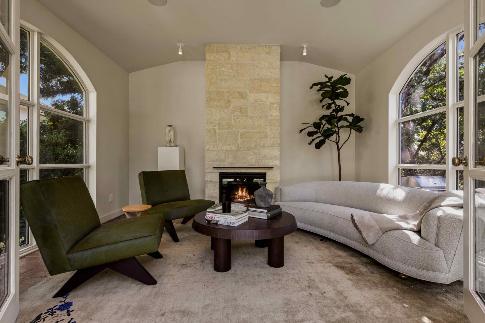 A custom Studio OSKLO coffee table complement a pair of Jeanneret chairs upholstered in emerald pony hair