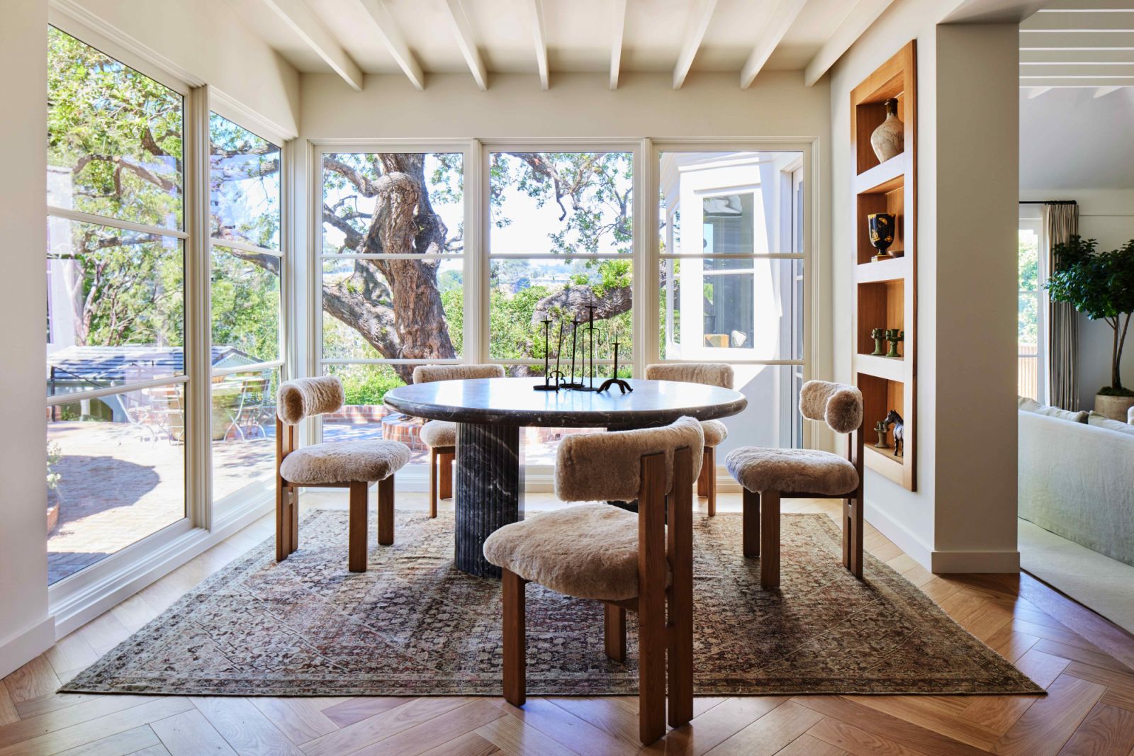Studio OSKLO dining chairs upholstered in natural shearling surround a custom table crafted in Arabescato Orobico Grigio marble (Photo: Sam Frost)