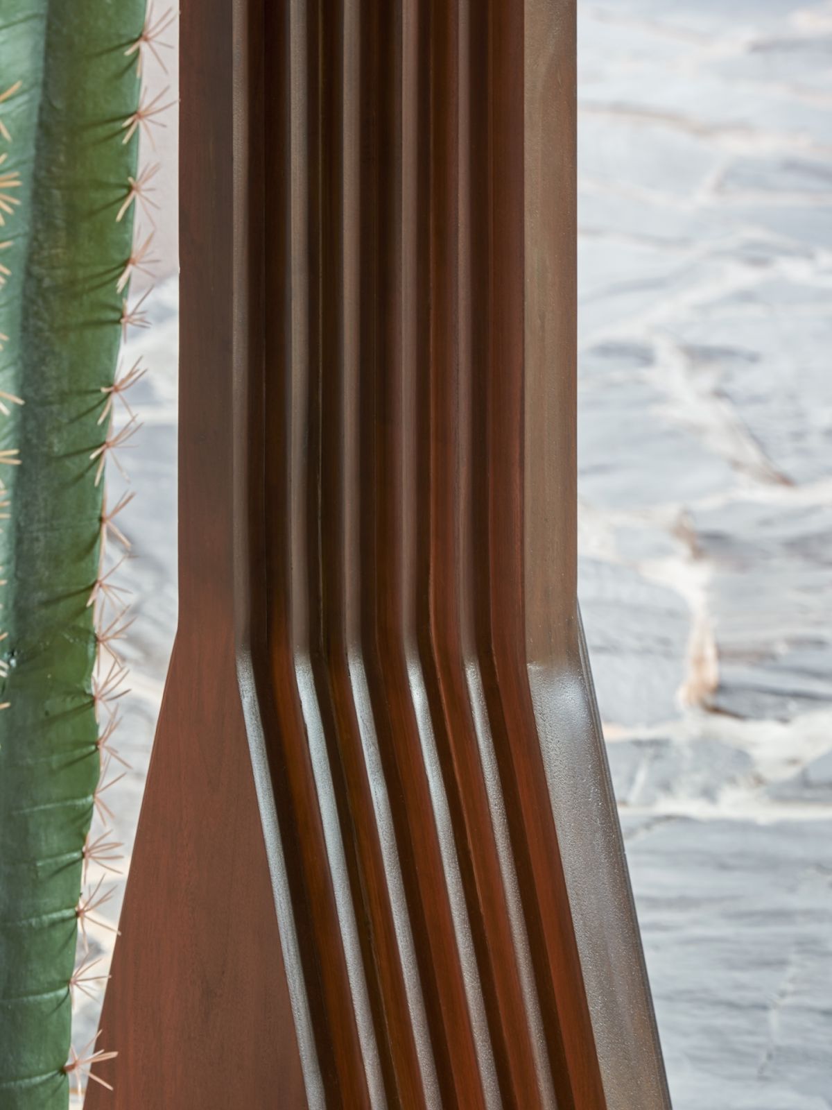 A carved solid wood table base by Dalisay Collection