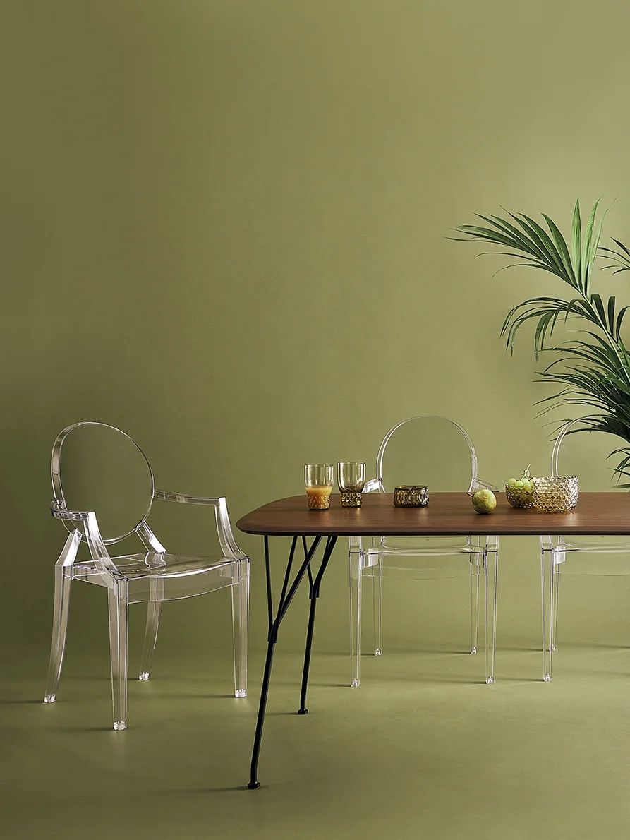 Designer Philippe Starck’s transparent polycarbonate Ghost dining chairs are styled with a mid-century modern table and natural plant decor (Photo: Kartell)