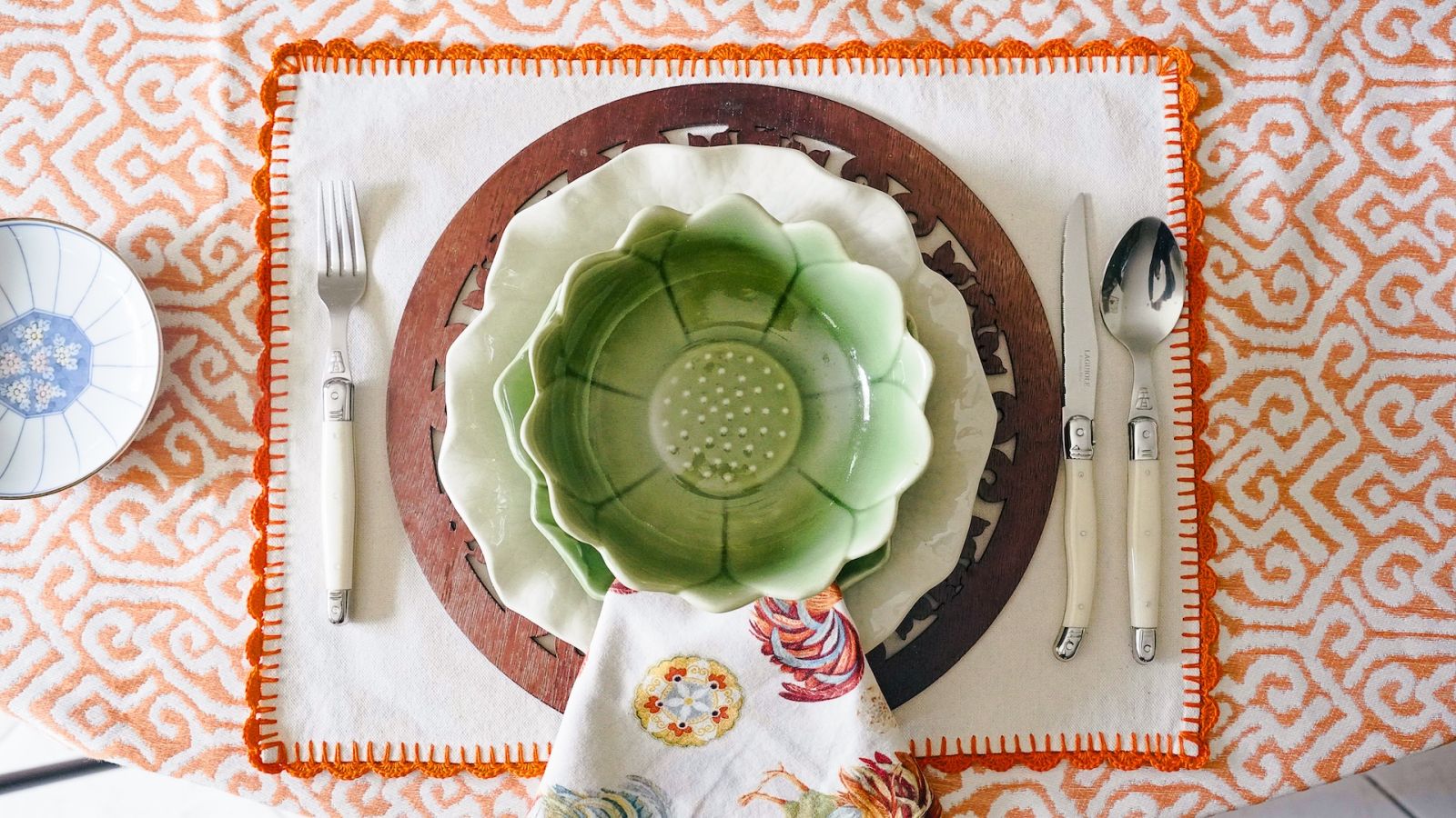 A green bowl contrasts with the colours and elements on the table