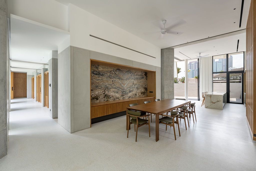 The dining area reveals a dramatic veined stone feature wall that anchors the space