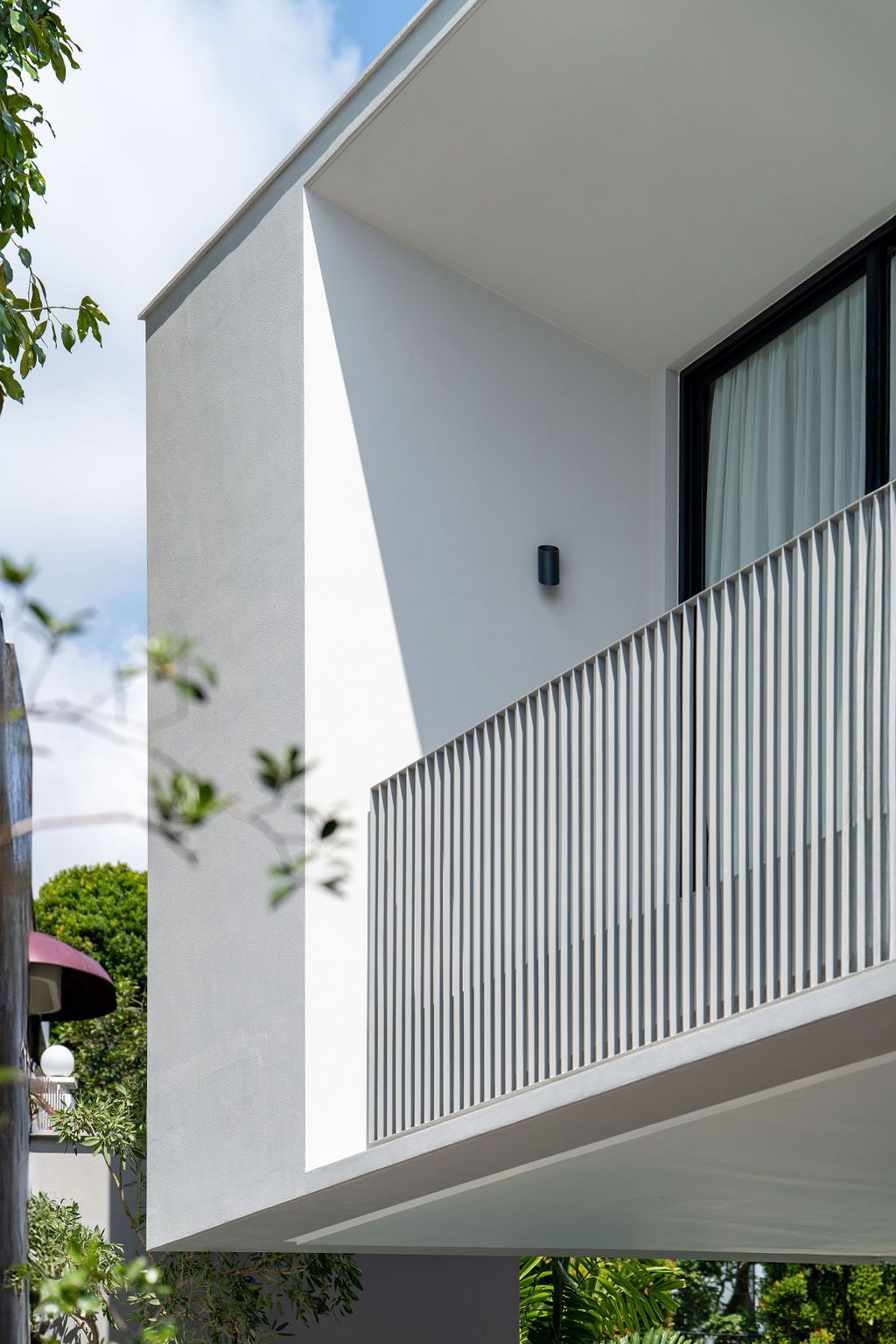 The minimal detailing of the upper volume features slender vertical balustrades that provide safety while maintaining visual lightness