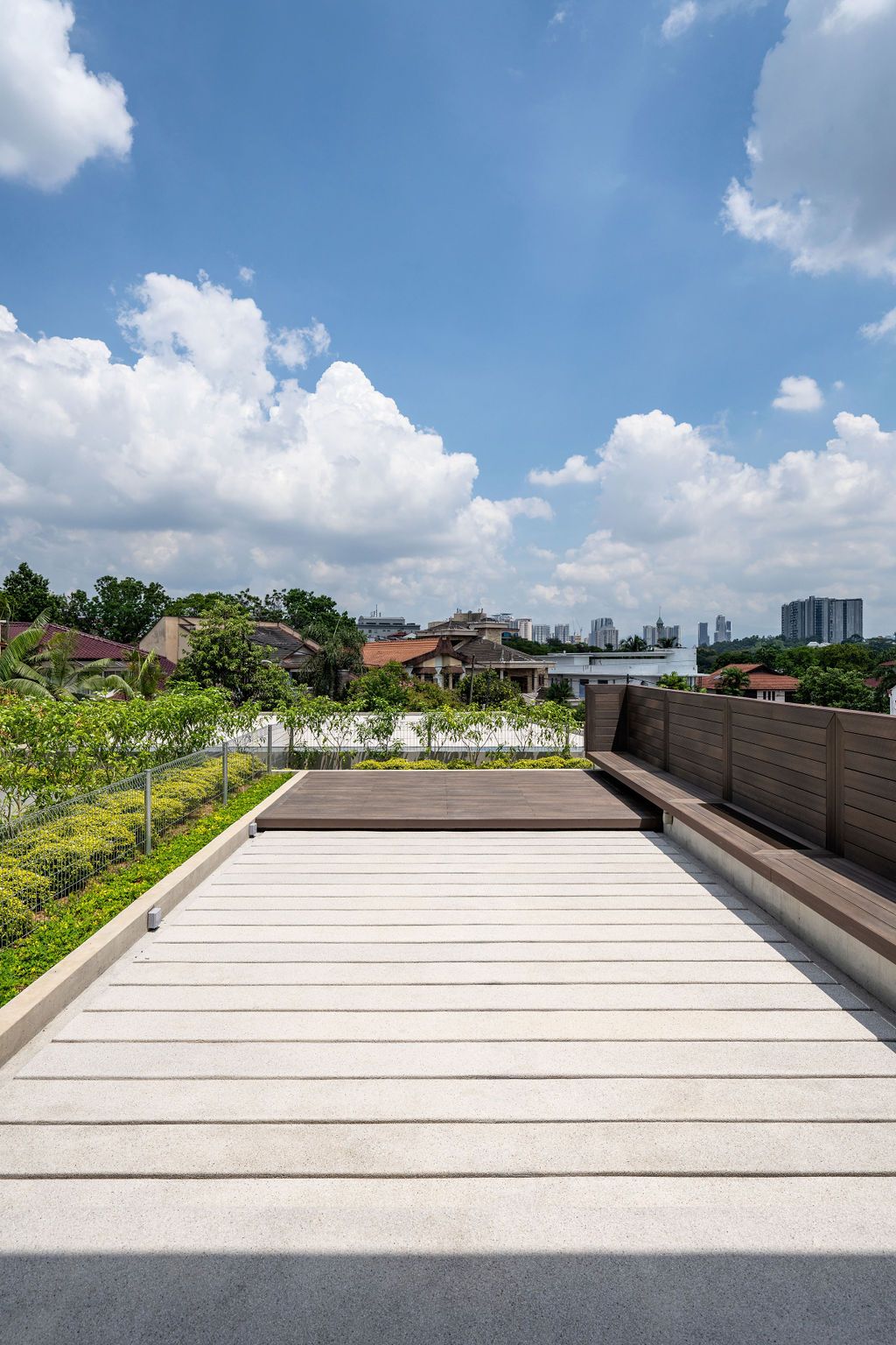 The timber-decked roof terrace provides the family with panoramic views across Bukit Damansara, with integrated planters creating resort-style villa living in the private upper domain.