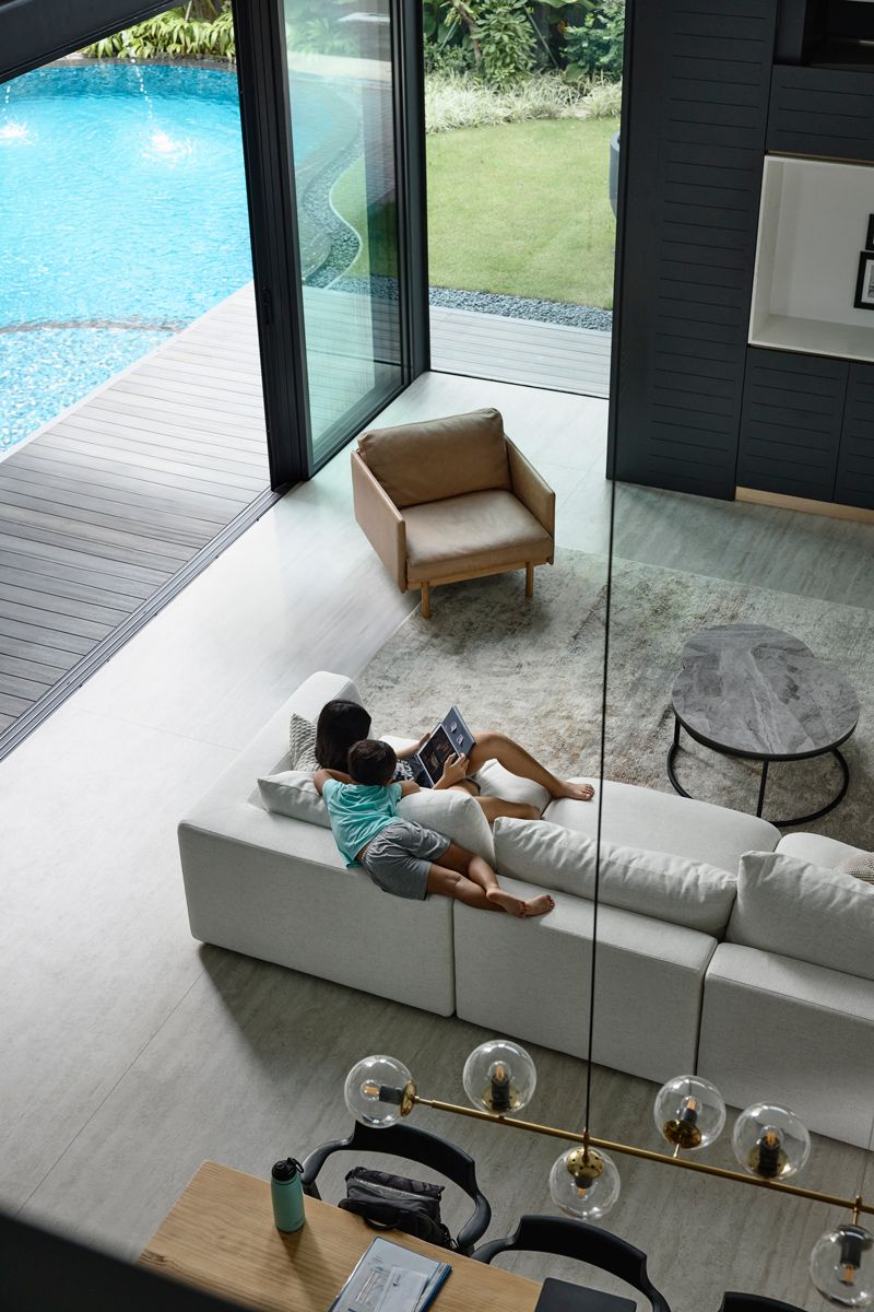 Seen from the second storey, the bungalow's double-height living area opens directly to the pond-like pool and garden