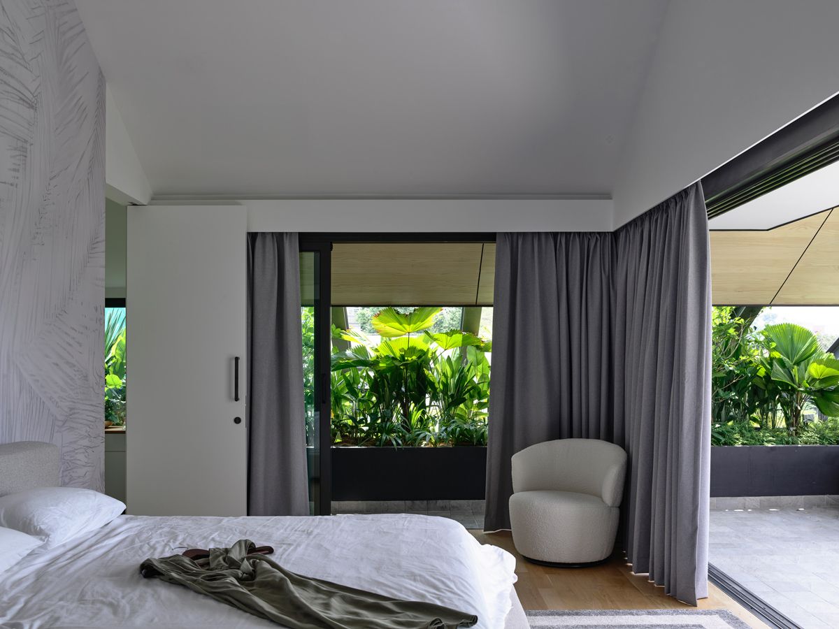 In the attic master suite, full-height glass doors open to a lush terrace, offering a serene buffer from the street
