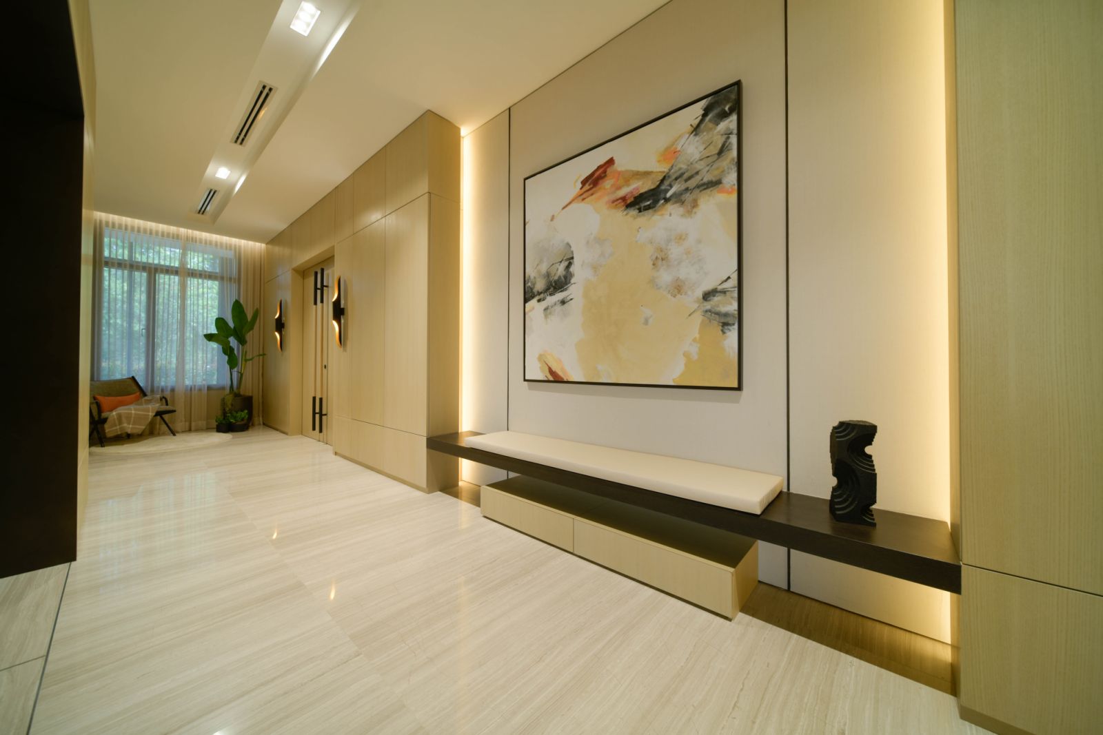 The private lift lobby, anchored by a floating bench and abstract artwork, sets a quiet, contemplative tone with timber wall panels and soft lighting