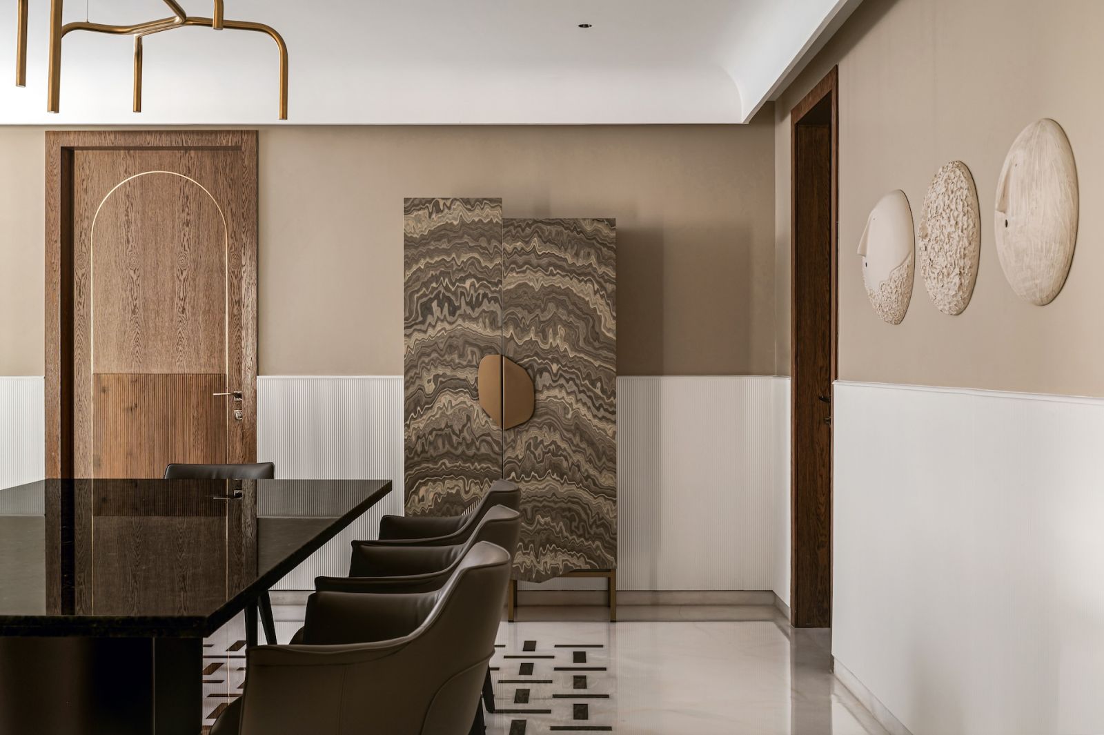 A more earthy palette in conversation with dynamic marble flooring in the dining room of a home in Bengaluru, India, designed by Studio GSA