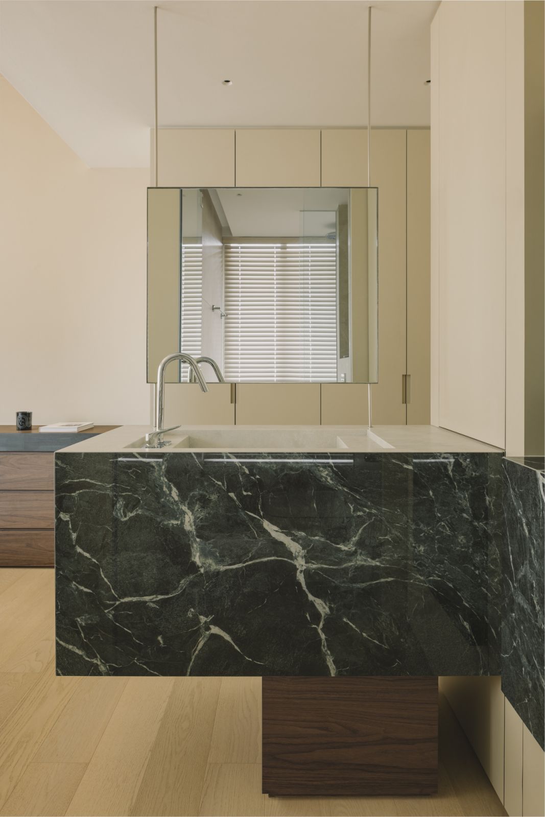 Mirrored and minimalist, the vanity echoes the bathroom beyond—establishing both visual rhythm and practical symmetry in this compact layout
