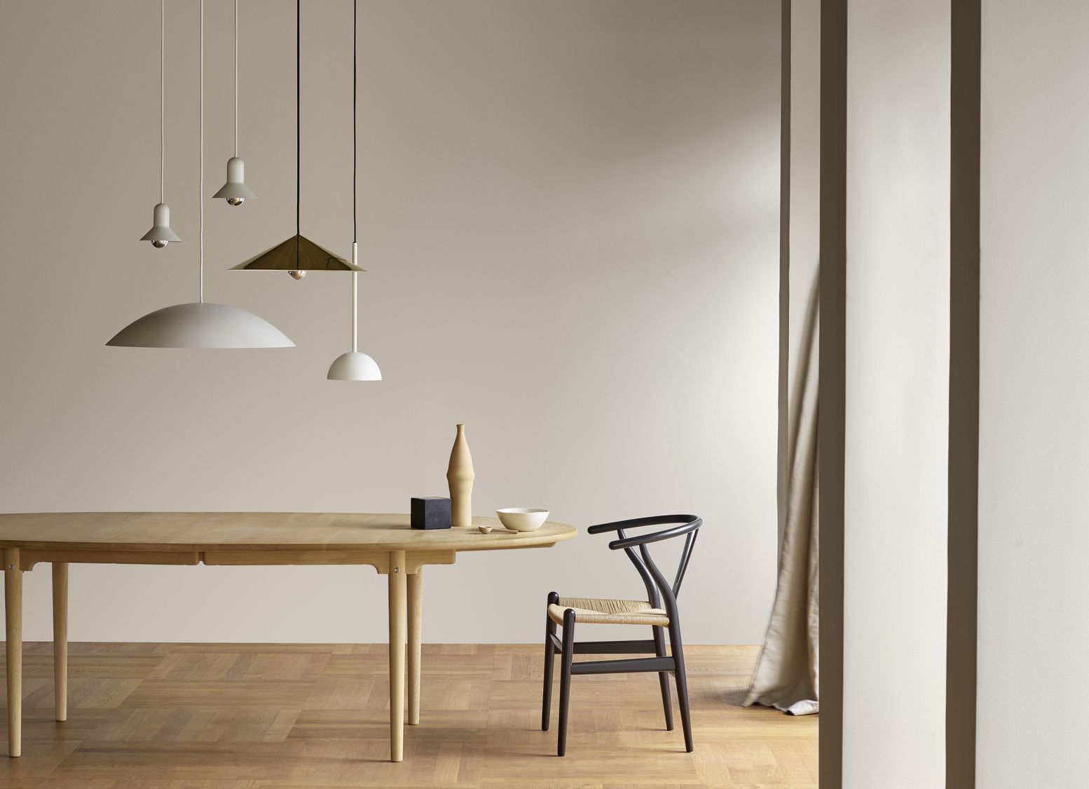 A black Wishbone Chair by Hans J. Wegner pairs with a minimalist oak dining table—an enduring icon handcrafted by Carl Hansen & Søn since 1950 (Photo: Carl Hansen & Søn)