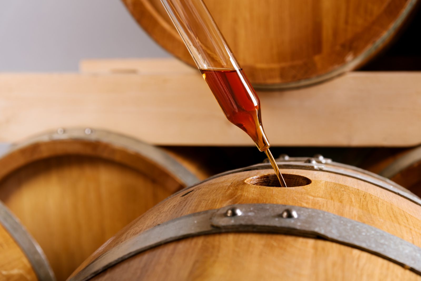 Close up view of female distillery owner sampling whiskey from barrel