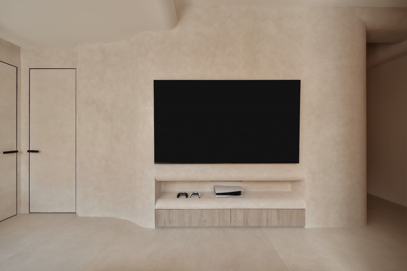 A softly sculpted feature wall anchors the living area, concealing storage and cable management while framing the TV in minimalist elegance