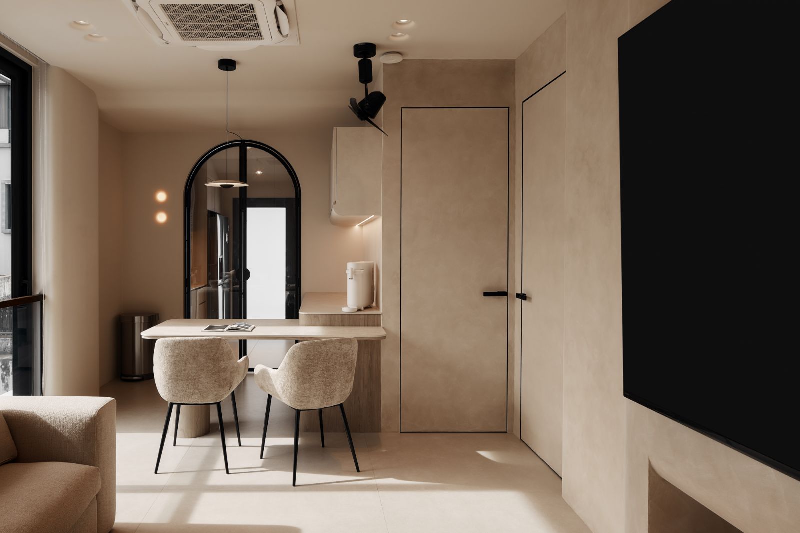 Arched black-framed glass doors lead into the kitchen, creating a visual focal point while subtly zoning the space