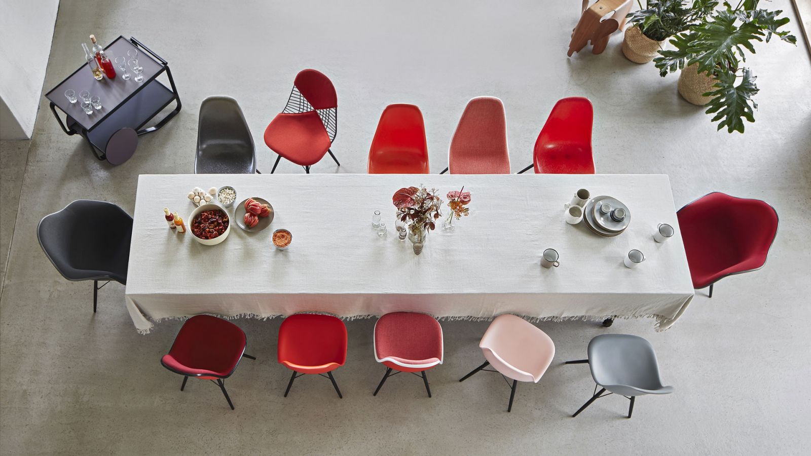 A dramatic arrangement of DSW chairs in bold red tones showcases the design’s enduring versatility, with upholstered and non-upholstered variants  (Photo: Vitra)