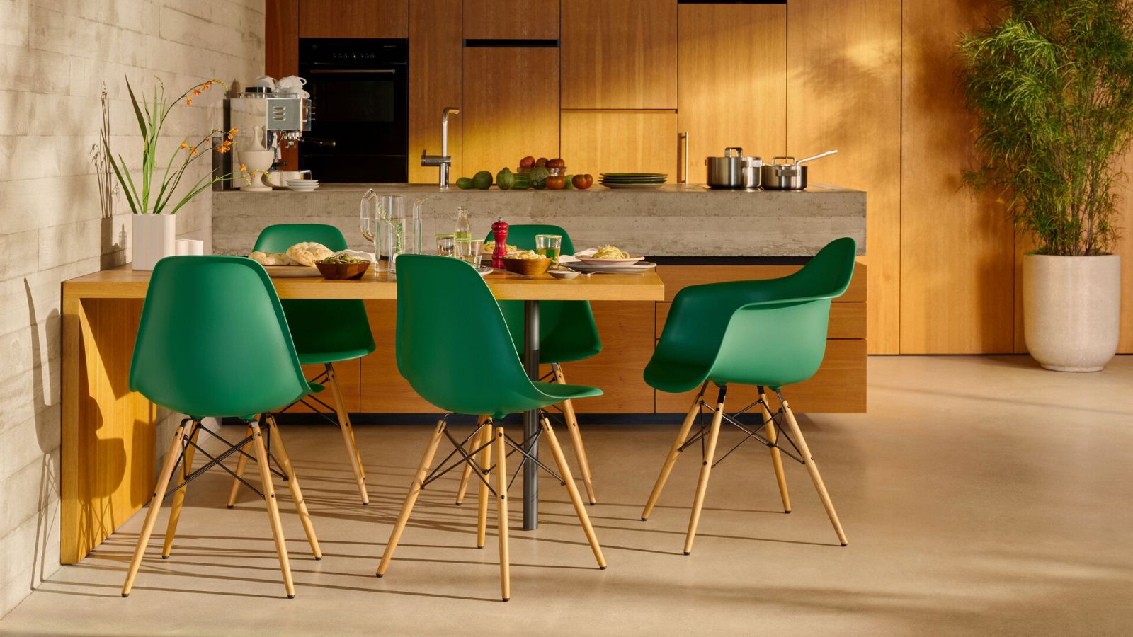 Vibrant emerald DSW chairs demonstrate the design’s adaptability in contemporary kitchens with the one-piece moulded construction and four-leg wooden base configuration (Photo: Vitra)