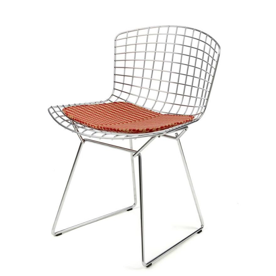 The classic polished chrome Bertoia side chair with orange cushion exemplifies the manufacturing precision achieved by Knoll since 1952 (Photo: Knoll)