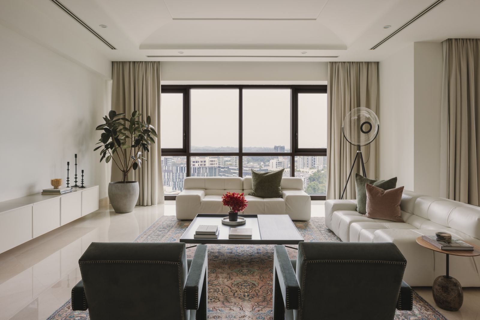 Bathed in natural light, the living room balances quiet minimalism with subtle character—framed by sweeping views of the city and grounded by plush textures and curated accents