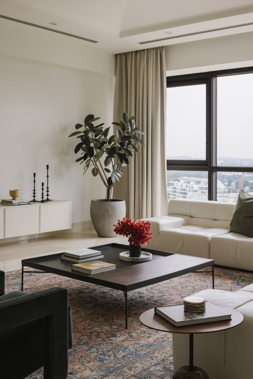 A low-profile coffee table anchors the living room with effortless elegance, styled with travel books, fresh florals and a quiet nod to symmetry
