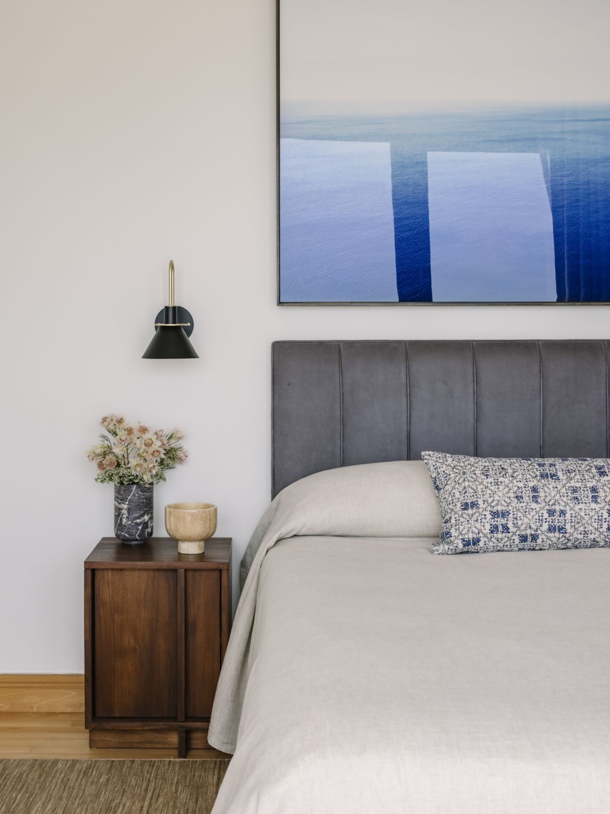 A palette of calming neutrals and ocean blues defines the master suite, where a plush bed and artisanal touches create a cocoon for rest