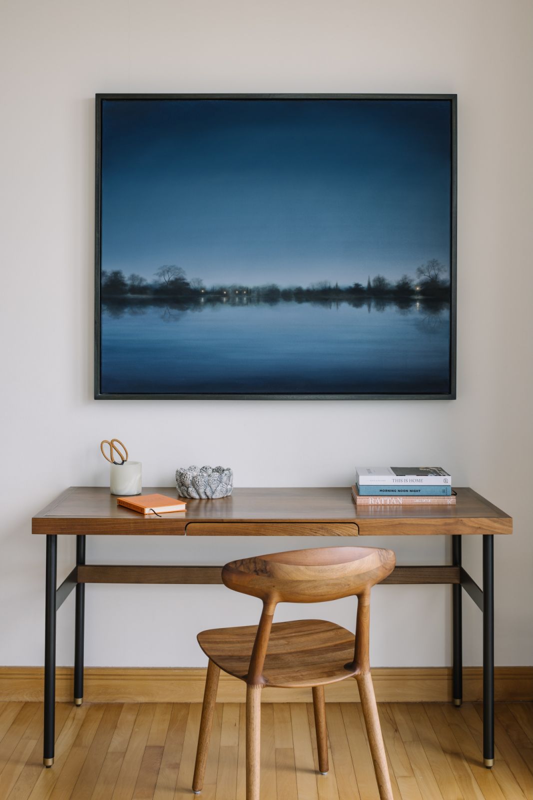 Rooted in simplicity, the study nook pairs clean lines with timber warmth and an atmospheric painting that evokes calm and clarity