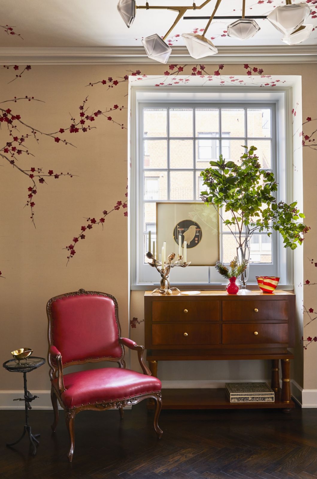 The entryway to a Japanese-inspired home on Park Avenue, New York designed by Phillip Thomas with hand-painted cherry blossoms designed in collaboration with De Gournay and a chandelier from the Myriad Series by Gabriel Scott