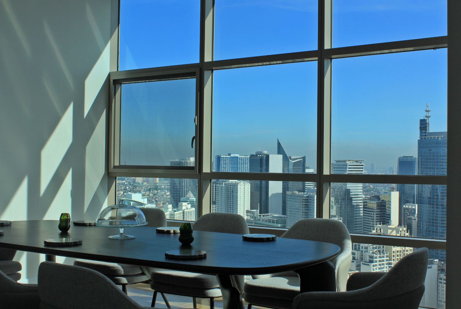 Panoramic views of Manila through the dining area of a Makati penthouse