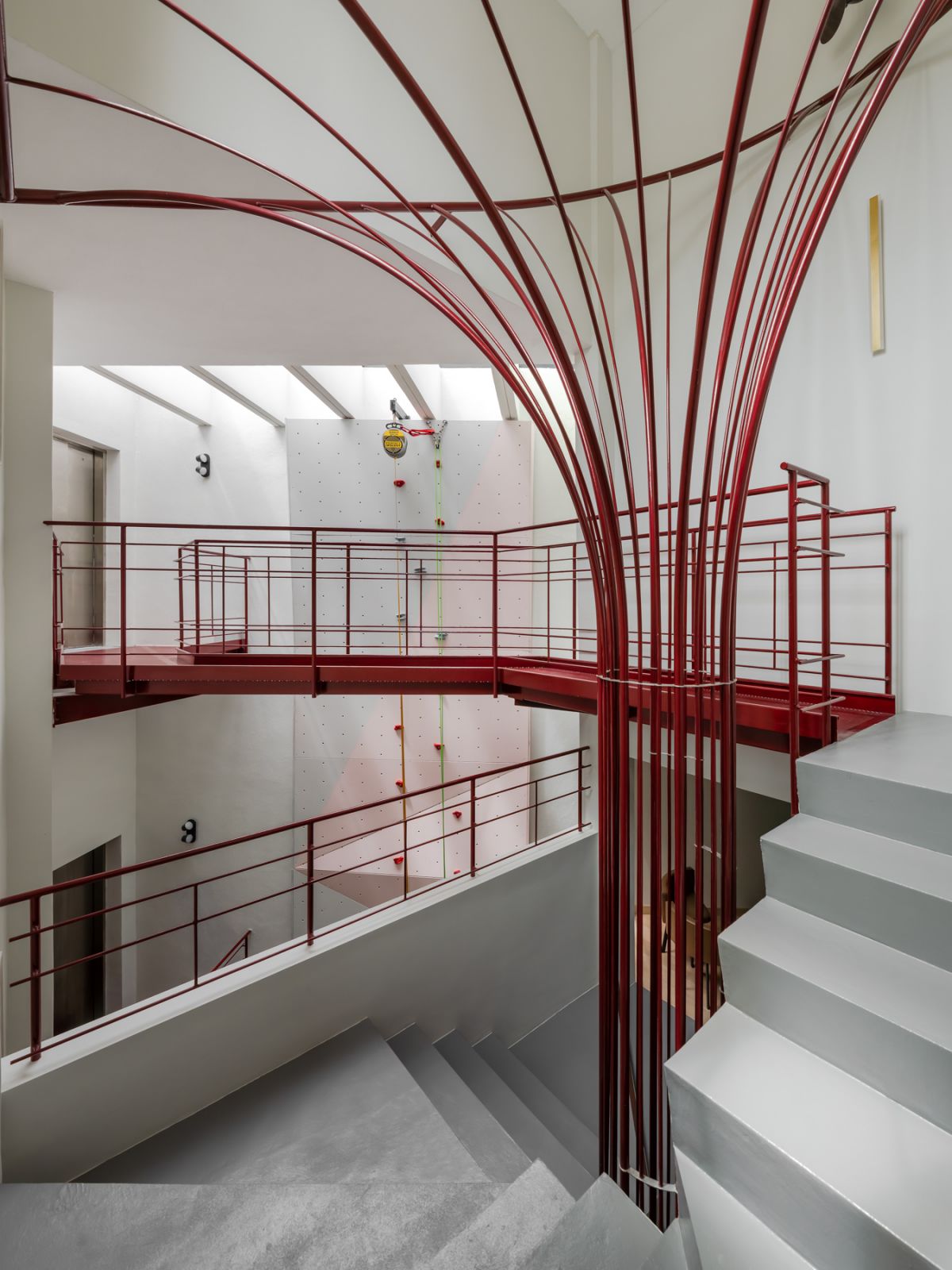 The striking central staircase doubles as a functional art piece, complemented by a rock-climbing wall