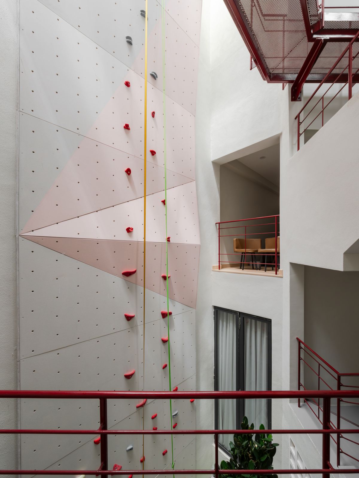 The custom rock climbing wall soars dramatically through all four stories of the home’s central courtyard