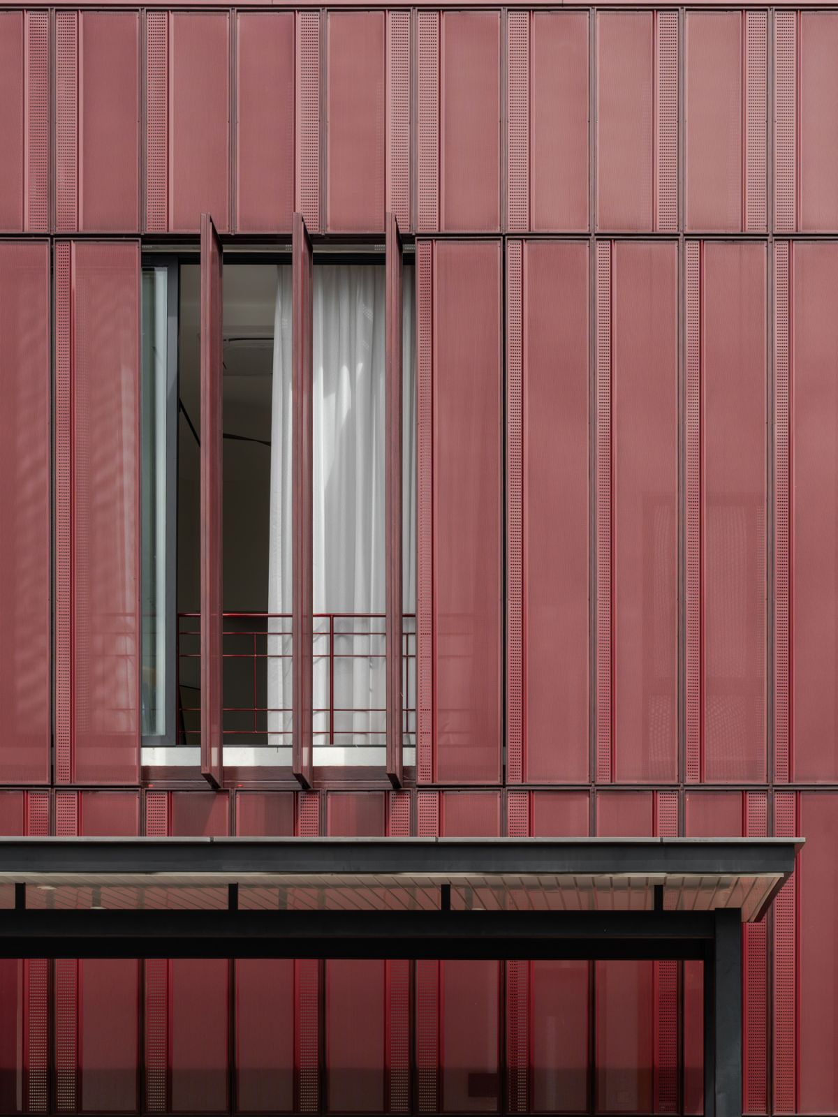 Red perforated screens filter sunlight into this entrepreneur’s reimagined split-level sanctuary