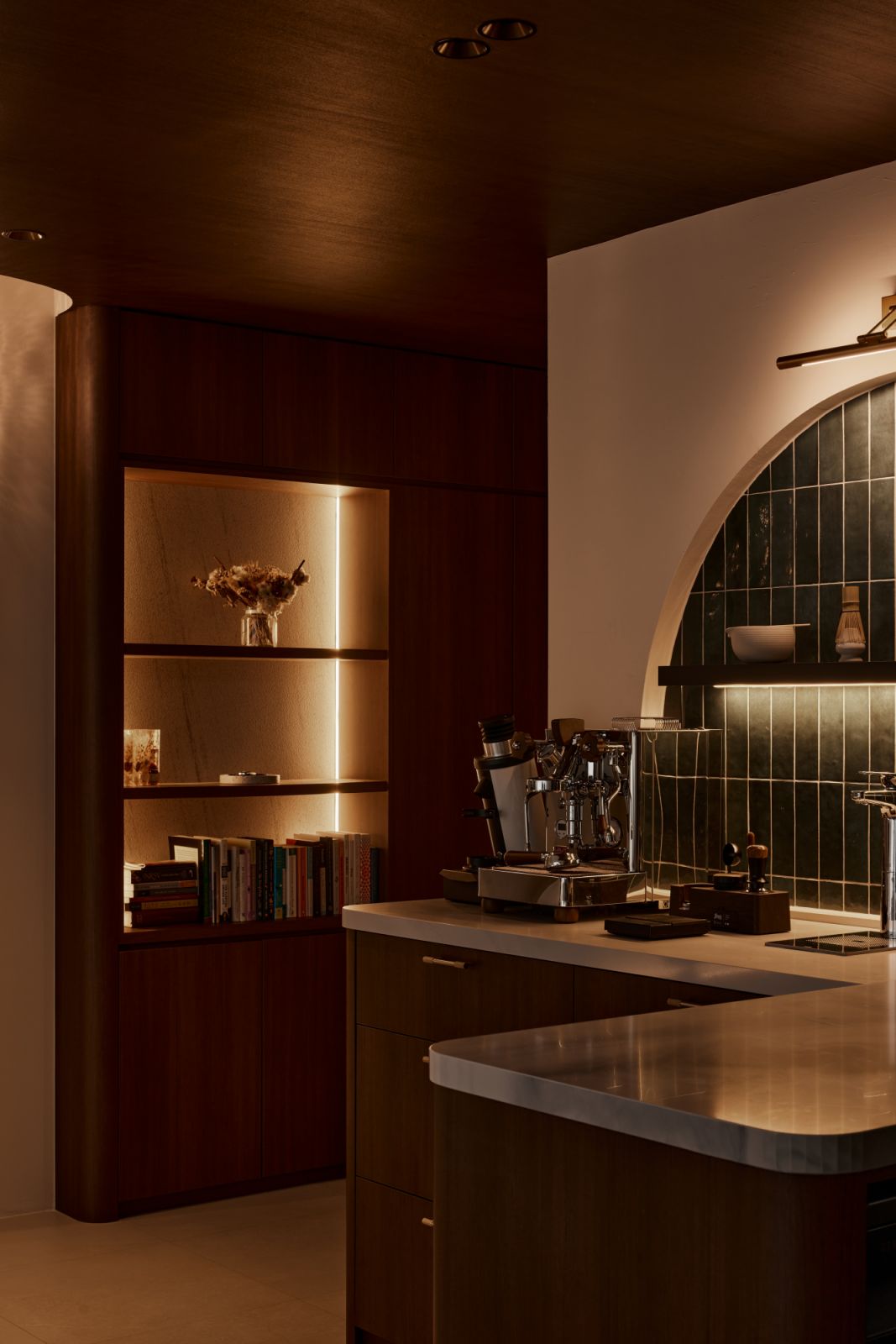 Framed by a curved built-in bookshelf, the coffee nook reflects the owners’ lifestyle priorities while adding charm and function to the kitchen