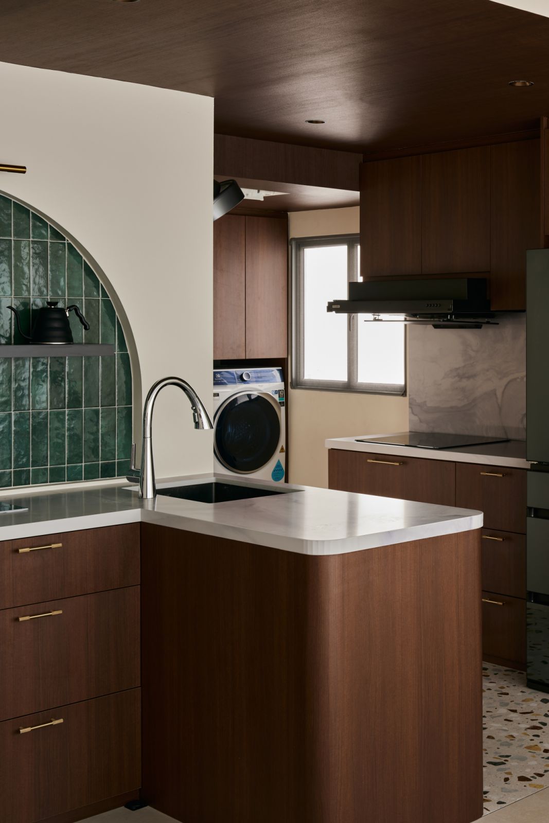 A quiet harmony of curves, stone and timber defines the working end of the kitchen, where sculptural flow meets everyday function