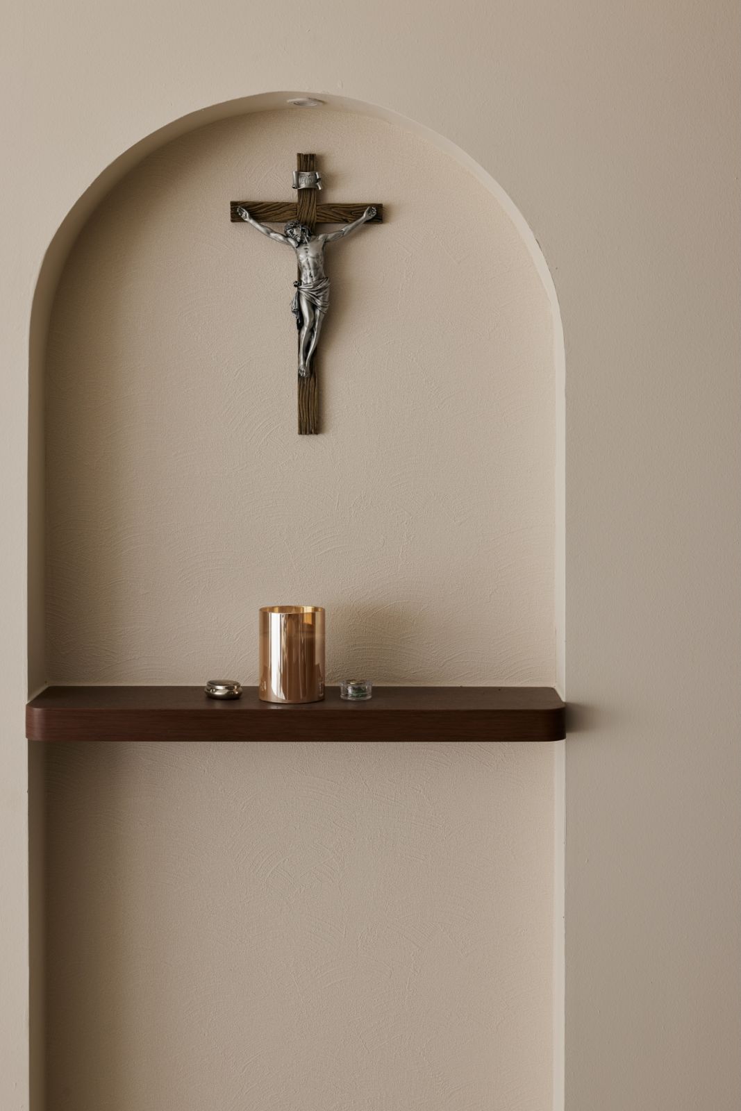 A detail of the arched niche altar, which brings a spiritual presence into the heart of the home—anchored by warm tones and a soft spotlight