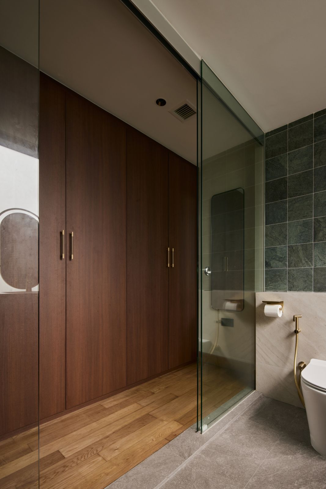 Floor-to-ceiling wardrobes in the bathroom are discreetly tucked behind glass partitions, offering storage without visual clutter