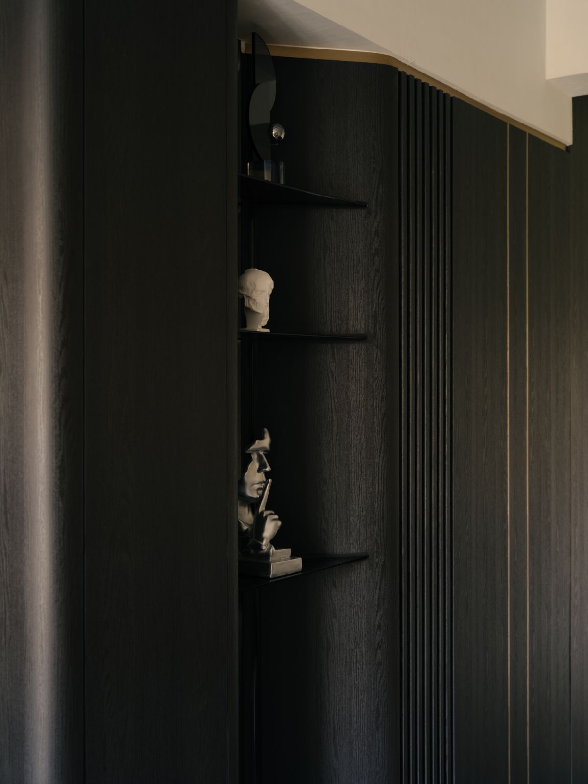 Clean architectural lines conceal thoughtful details, such as this recessed niche that spotlights an artful display of collected sculptures