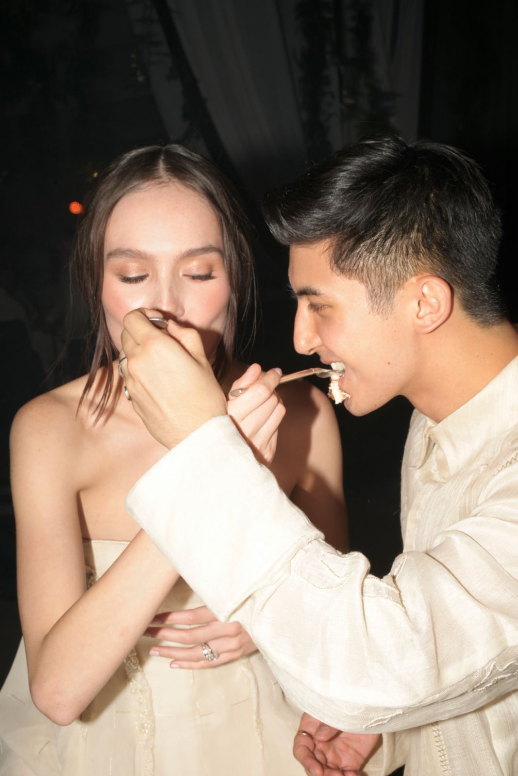 Feeding each other the first bites of the wedding cake by Cibo