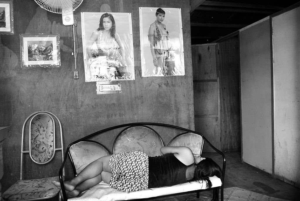 A sex worker sleeps outside a brothel in the slum area of Camagayan district April 14, 2004, in Cebu, Philippines. In many countries, a large portion of injecting drug users are also HIV positive. A million people in the Asia and Pacific region became infected with HIV in 2003, while more than half a million people died from AIDS-related causes. UNAIDS says that the appalling figures will be higher in 2004. (Photo: Palani Mohan/Getty Images)