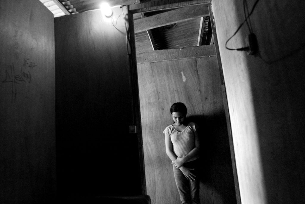 A sex worker waits for a client outside a brothel room in the slum area of Camagayan district April 14, 2004 in Cebu, Philippines. Injectable drug use is a growing problem in the Asia and Pacific region, and in many countries, a large portion of injecting drug users are also HIV positive (Photo: Palani Mohan/Getty Images)