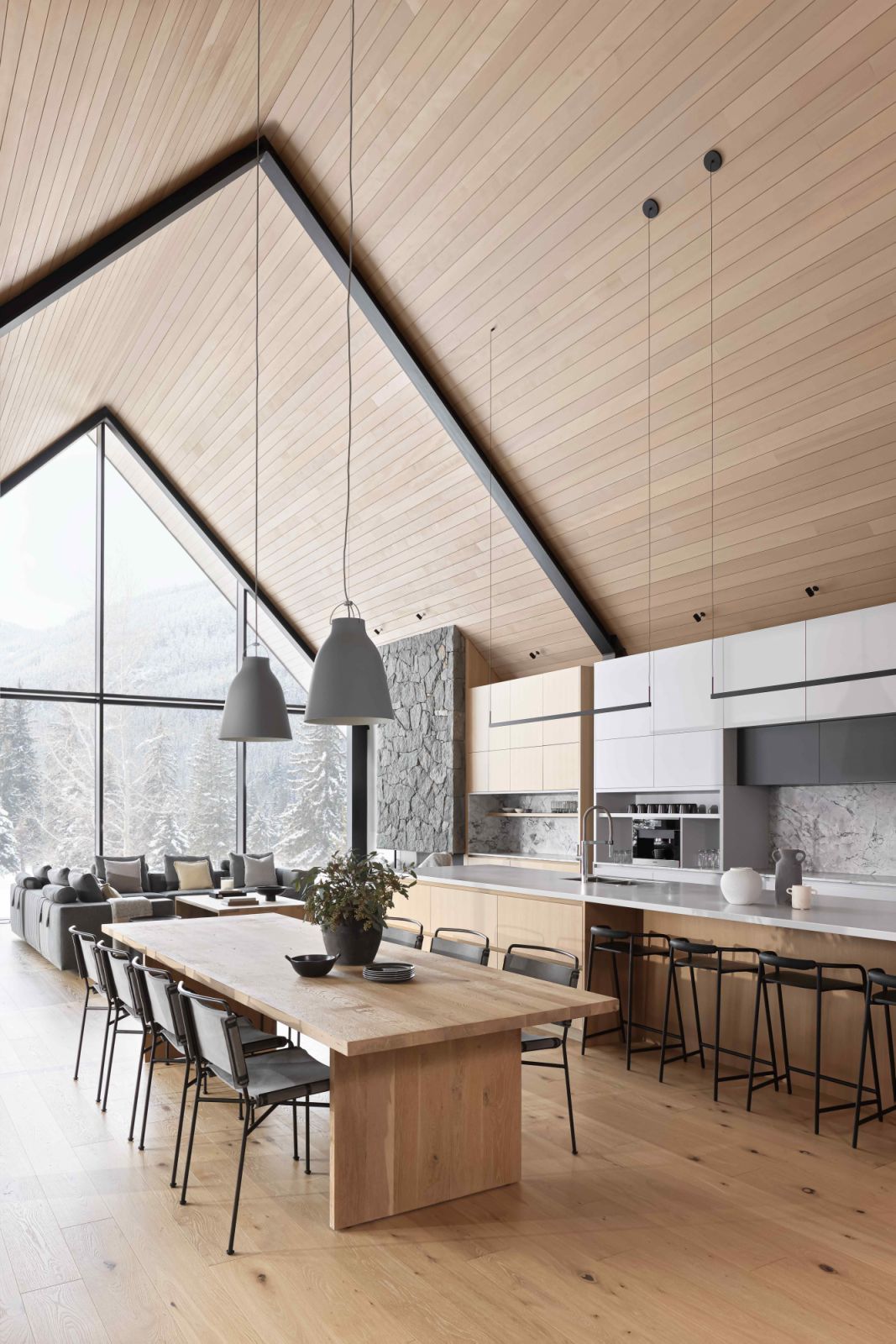 The open-plan living spaces benefit from the high, pitched ceilings and floor-to-ceiling windows